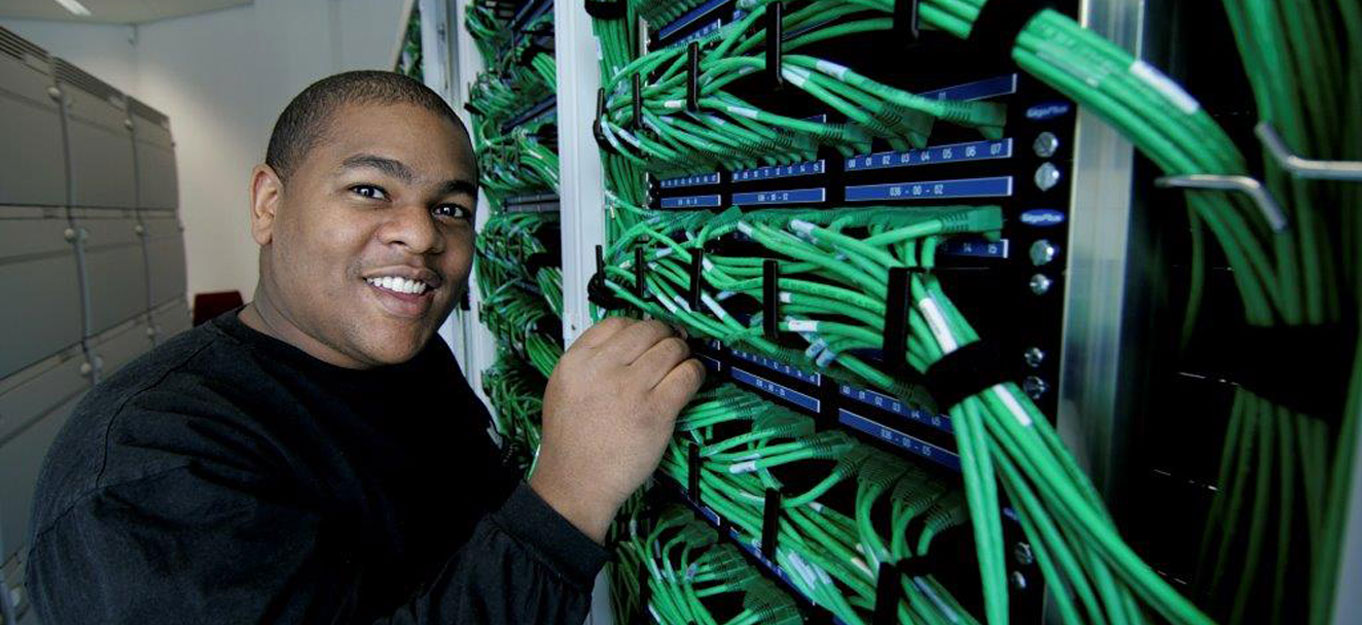 IT Services photo with young man with cables that shows CommFed Solution services